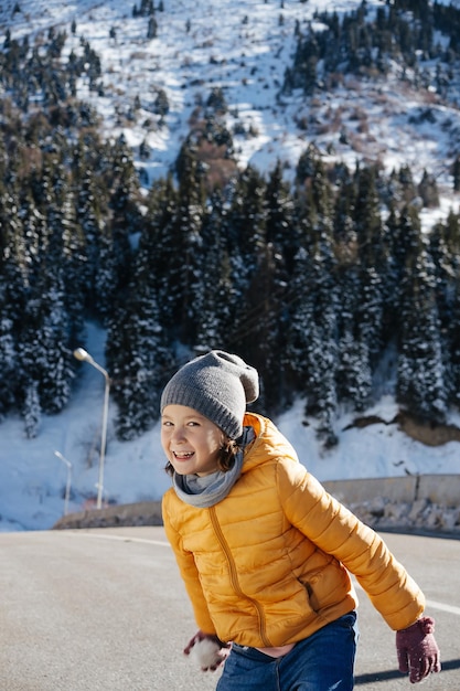 Foto niña alegre descarada en un puente estrecho con bola de nieve esperando