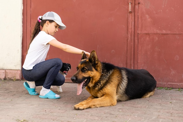 Niña alegre con un perro pastor alemán.