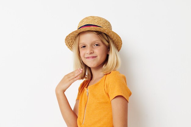 Niña alegre con un sombrero de moda posando fondo claro