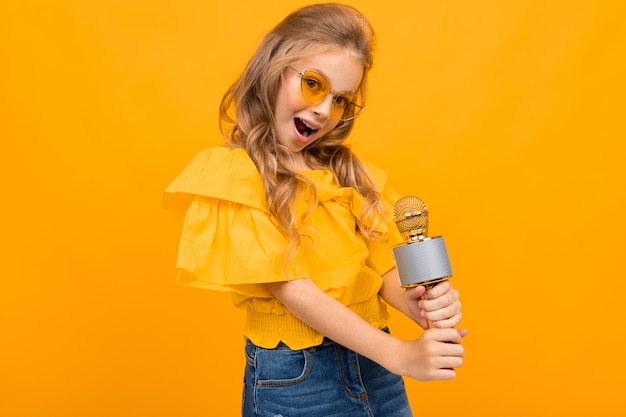 Niña alegre sonrisas aisladas sobre fondo amarillo