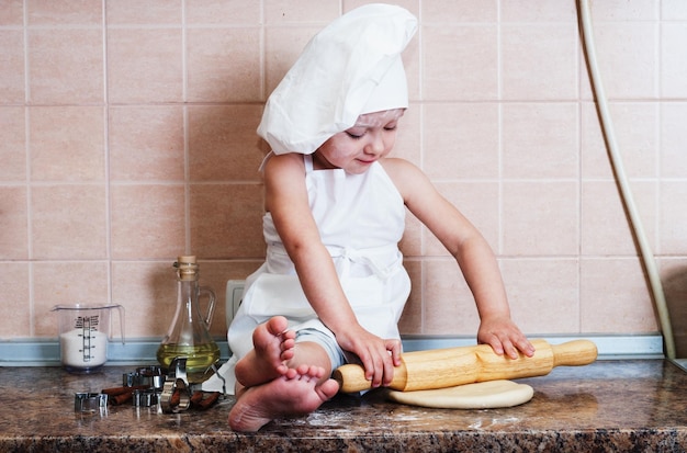 niña amasando masa en la cocina