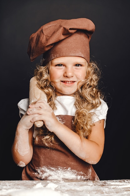 Niña amasar en la mesa