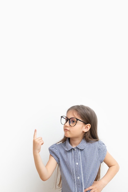 Una niña de un año con anteojos señala con el dedo el formato vertical del concepto de aprendizaje de educación infantil