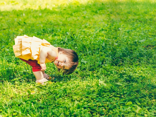 Niña de un año jugando boca abajo en la calle