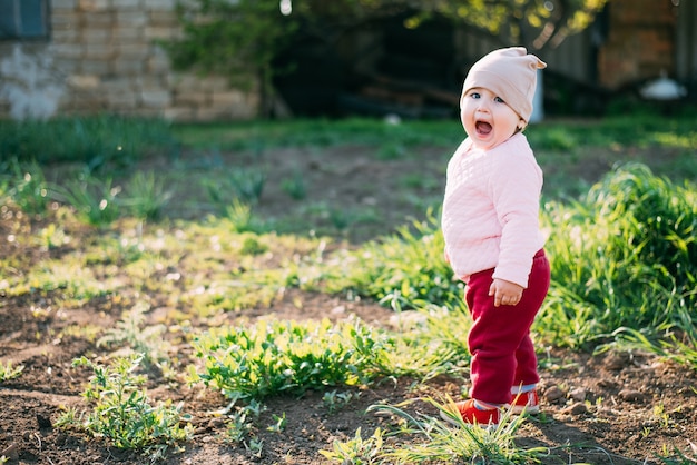 Niña de un año jugando en el pueblo al aire libre.