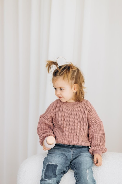 La niña aprende los colores jugando con figuras humanas cilíndricas de madera de colores y colocándolas en tazas del color apropiado El niño está feliz de haber completado la tarea correctamente