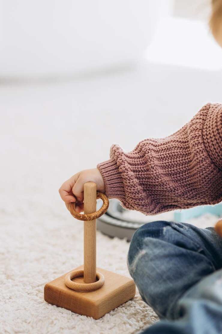 La niña aprende los colores jugando con figuras humanas cilíndricas de madera de colores y colocándolas en tazas del color apropiado El niño está feliz de haber completado la tarea correctamente