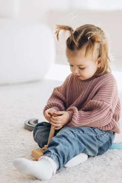 La niña aprende los colores jugando con figuras humanas cilíndricas de madera de colores y colocándolas en tazas del color apropiado El niño está feliz de haber completado la tarea correctamente