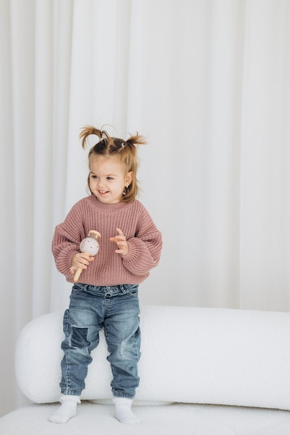 Foto la niña aprende los colores jugando con figuras humanas cilíndricas de madera de colores y colocándolas en tazas del color apropiado el niño está feliz de haber completado la tarea correctamente