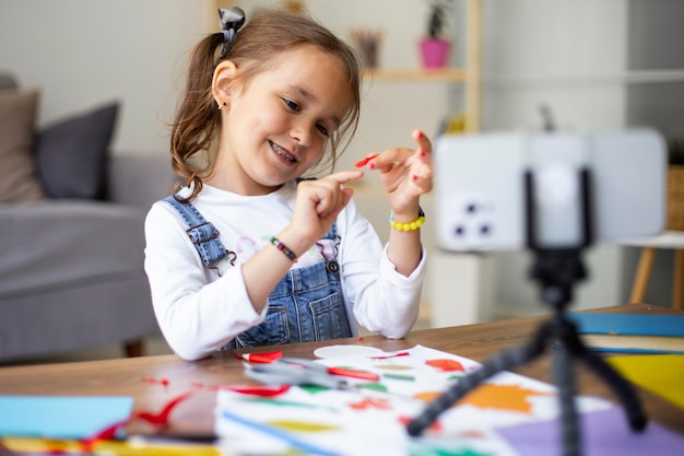 Foto niña aprendiendo a hacer manualidades.