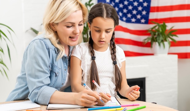 Niña aprendiendo inglés con el profesor.