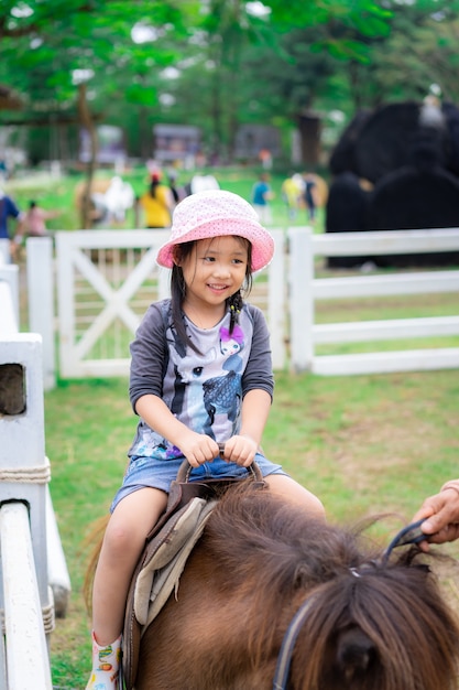 Niña aprendiendo a montar a caballo