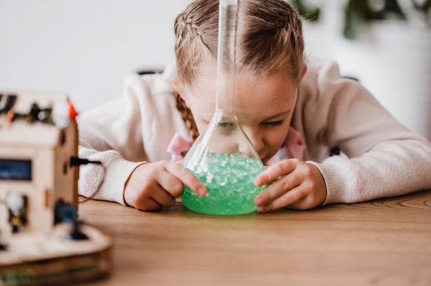 Niña aprendiendo sobre elementos químicos en clase.