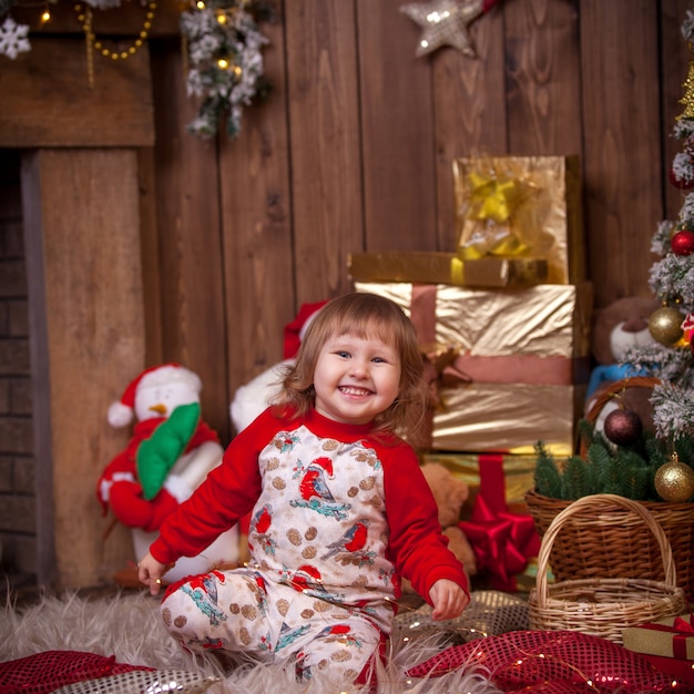 niña en el árbol de Navidad con regalos