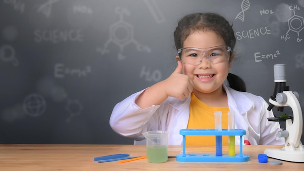 Niña asiática aprendiendo química científica con tubos de ensayo haciendo experimentos en el laboratorio escolar. concepto de educación, ciencia, química y niños. Desarrollo temprano de los niños.