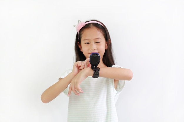 Niña asiática con cámara de vídeo reloj inteligente sobre fondo blanco. Centrarse en el reloj inteligente en sus manos