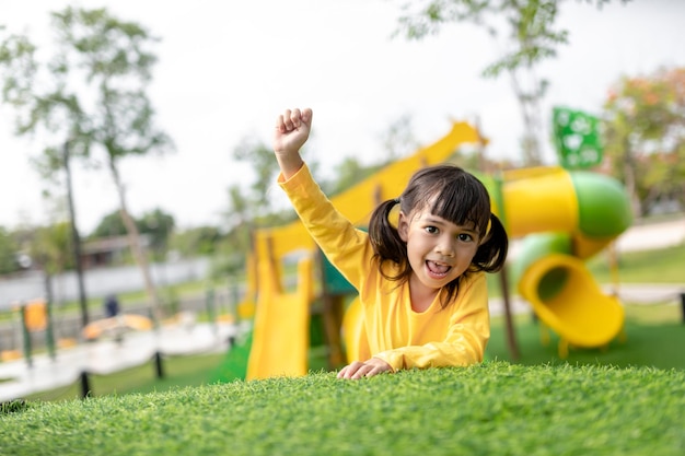 Niña asiática disfruta jugando en un parque infantil Retrato al aire libre