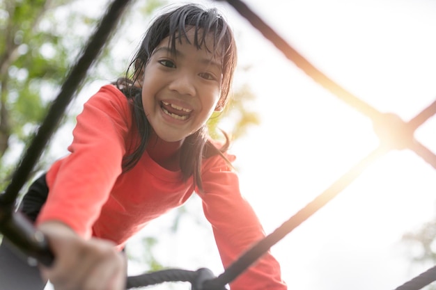 Niña asiática disfruta jugando en un parque infantil Retrato al aire libre