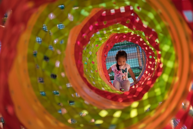 Niña asiática disfruta jugando en un patio de niños