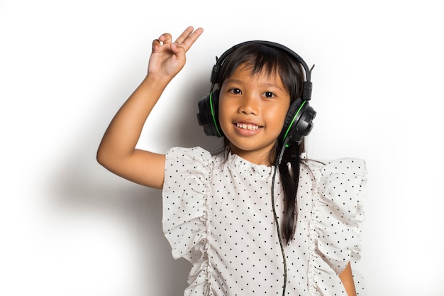 Niña asiática disfrutando de la música. bailar y moverse expresando verdaderas emociones positivas