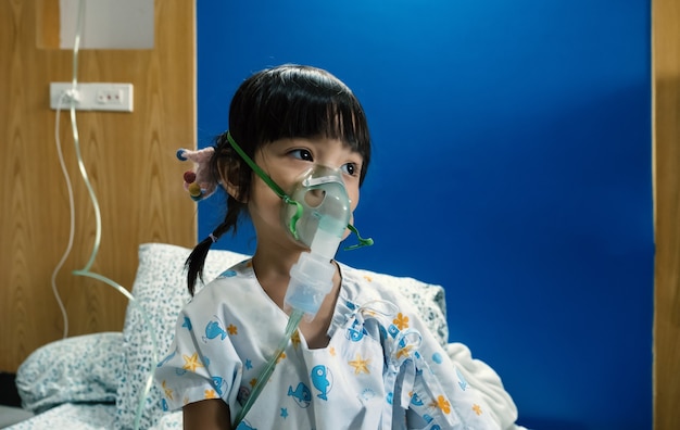 Foto una niña asiática enferma se fumigó por la nariz para matar la esterilización pulmonar.