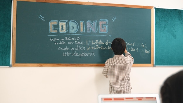 Niña asiática escribiendo instrucciones de ingeniería usando software de IA en la clase de pedagogía