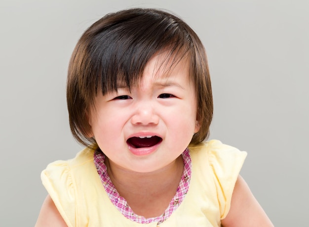 La niña asiática está llorando.