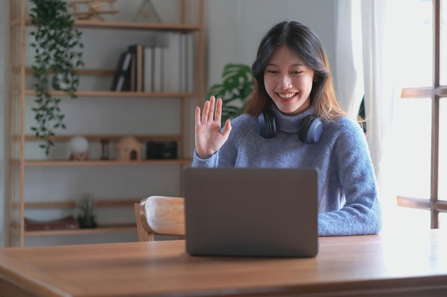 Niña asiática estudiante de aprendizaje en línea clase de estudio en línea video llamada zoom maestro feliz niña asiática aprender inglés en línea con computadora portátil