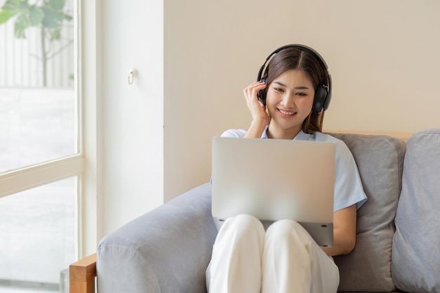 Niña asiática estudiante de aprendizaje en línea clase de estudio en línea video llamada zoom maestro feliz niña asiática aprender inglés en línea con computadora portátil