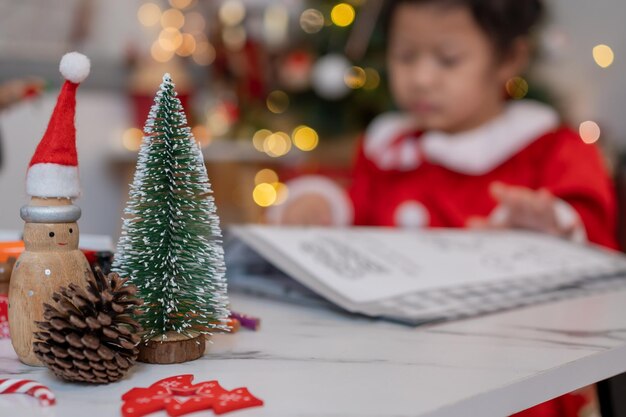 Una niña asiática feliz se divierte en la fiesta de Navidad en la sala de estar con decoración en casa.