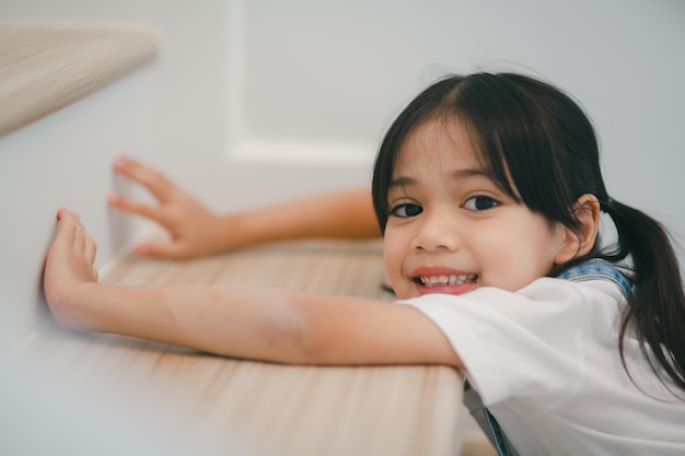 Niña asiática feliz divirtiéndose en las escaleras