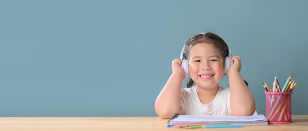 Una niña asiática feliz que estudia la clase de aprendizaje en línea en casa. Concepto de educación e-learning o educación en el hogar. Nueva normalidad, coronavirus Covid-19, distanciamiento social.