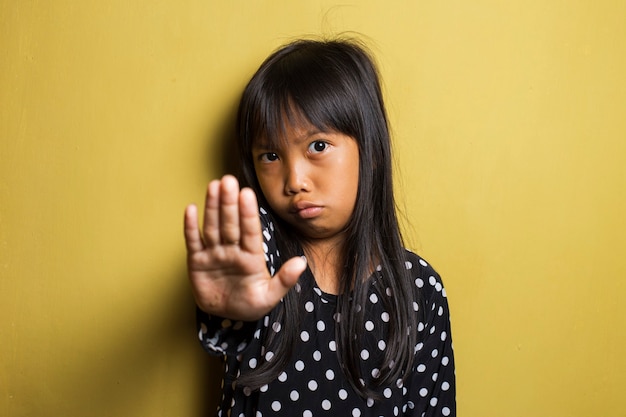 Foto niña asiática haciendo gesto de parada con la mano