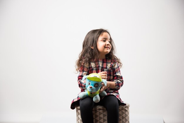 Niña asiática india jugando con un peluche de peluche