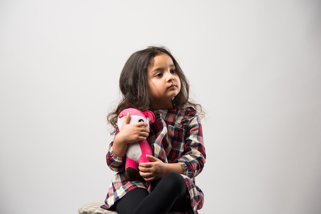 Niña asiática india jugando con un peluche de peluche