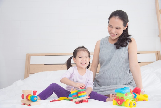 Niña asiática jugando juguete con su madre