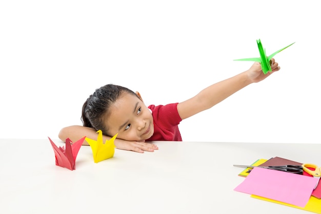 Niña asiática jugando con papel de ganso aislado sobre fondo blanco.