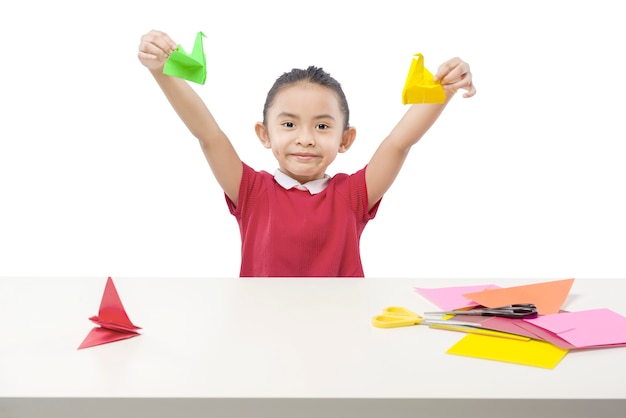 Niña asiática jugando con papel de ganso aislado sobre fondo blanco.