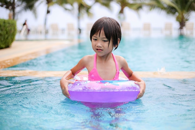 Niña asiática jugando en la piscina