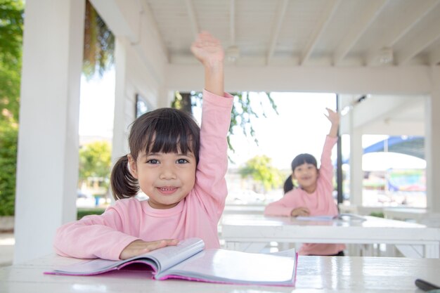 Niña asiática en la lección en el aula