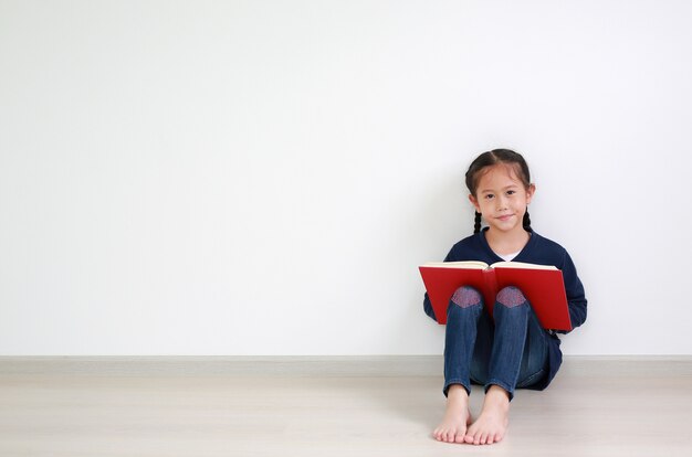 Niña asiática leyendo un libro