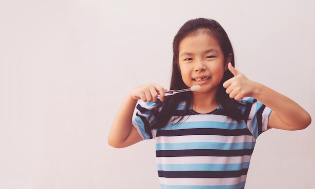 Niña asiática linda cepillo de dientes