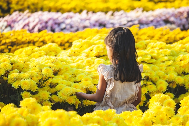 Niña asiática linda niña amor flor y divertirse con hermosa flor en el jardín de flores