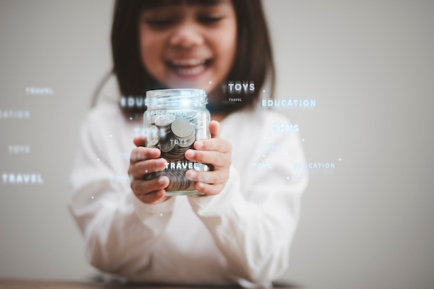 Foto niña asiática linda del niño que hace pilas de monedas. kid ahorra dinero para la educación futura. concepto de dinero, finanzas y personas