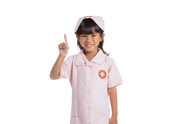 Niña asiática linda que lleva un uniforme médico