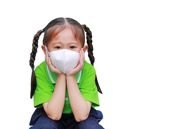 Niña asiática con una máscara de protección contra la contaminación del aire y el virus de la corona covid19 aislada en fondo blanco con espacio para copiar