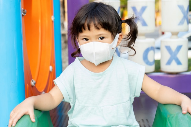 Niña asiática con máscara para proteger el concepto de coronavirus