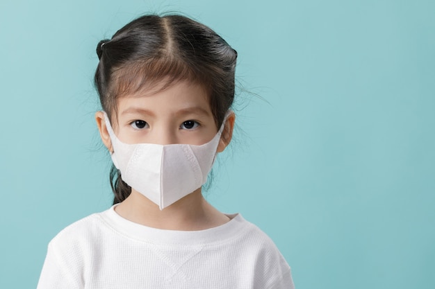 Niña asiática con máscara de respirador para detener el brote de coronavirus, Nuevo virus Covid-19