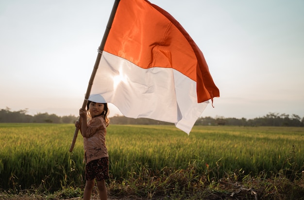 Niña asiática ondeando la bandera de Indonesia