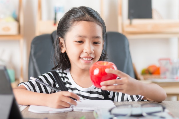 Niña asiática que hace la tarea